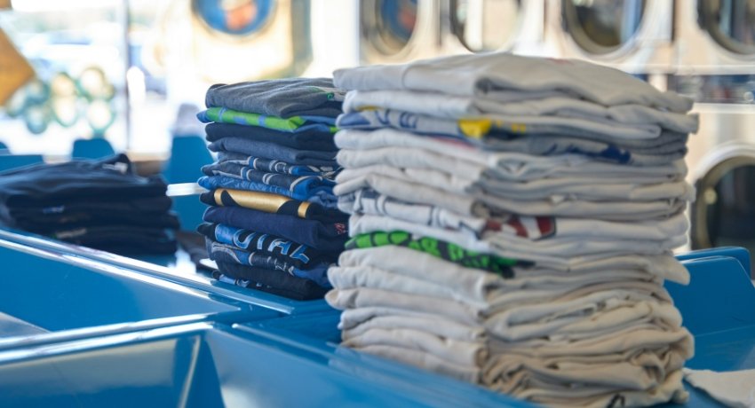 Travellers using self-service laundry machines in Dublin laundromat